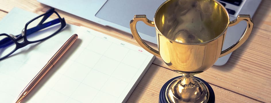 Trophy and planing book on working table , winner